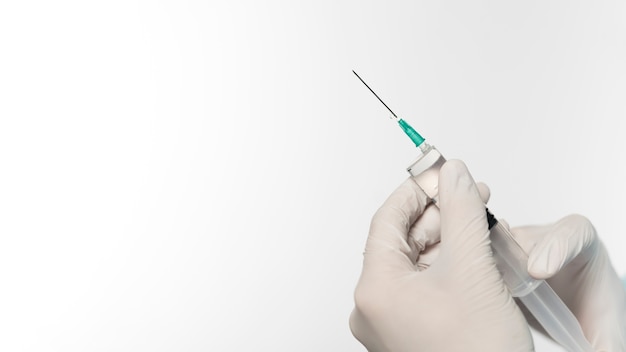 Side view of doctor with surgical gloves holding syringe