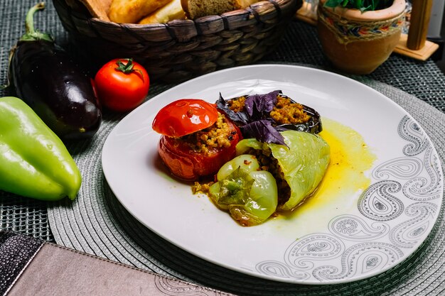 Side view dolma stuffed tomato bell pepper and eggplant with minced meat and basil