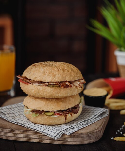 Side view of doner kebab in pita bread on top of each other on a wooden board