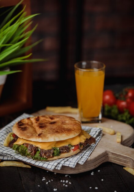 Side view of doner kebab in pita bread on a wooden board