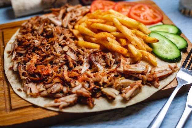 Side view doner on pita with french fries fresh cucumber and tomato