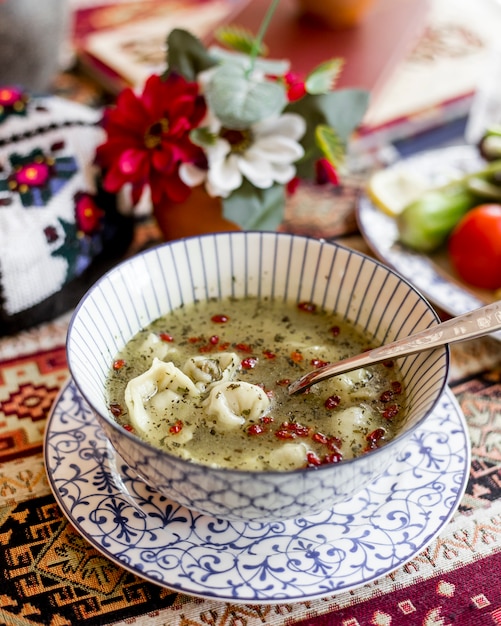 Side view dumplings soup with dried barbarry and mint on a plate