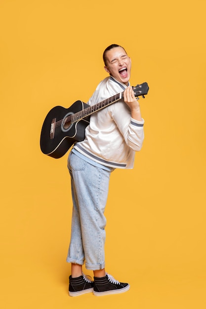 Side view of ecstatic woman holding guitar