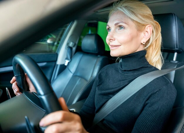 車を運転する高齢者のビジネス女性の側面図