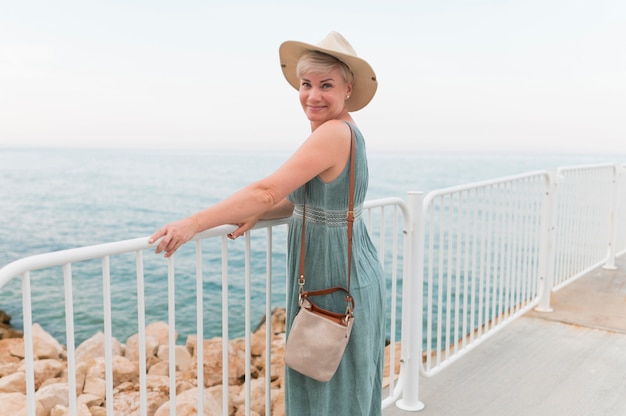 Free photo side view of elder tourist woman at the beach