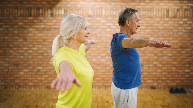 Free photo side view of elderly couple in gym