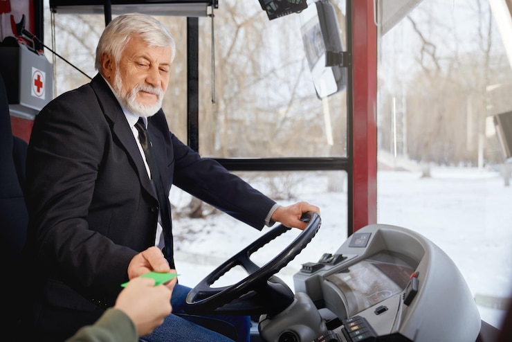 Free Photo side view of elderly driver in black jacket sitting at steering wheel holding ticket and crop of