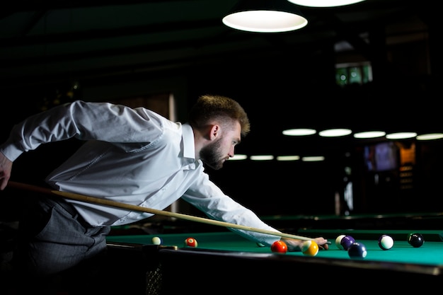 Free photo side view elegant guy playing billiard