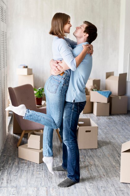 Side view of embraced couple at home on moving out day