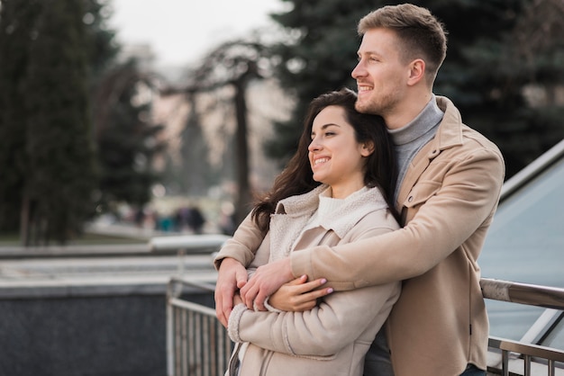 Free photo side view of embraced couple outdoors