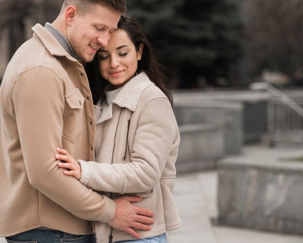 Side view of embraced couple outdoors