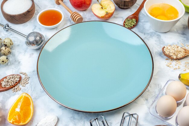Side view of empty blue plate and ingredients for the healthy food set on ice surface