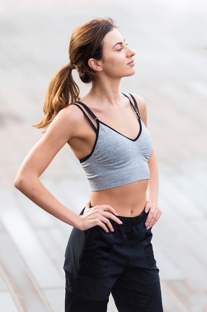 Side view of exercising woman posing in athleisure
