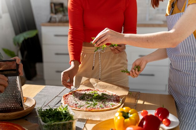 Free photo side view family cooking delicious pizza