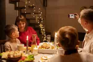 Free photo side view family members sitting at table