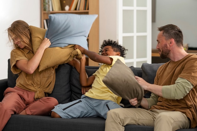 Side view family playing with pillows