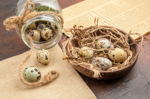 Side view of farm fresh eggs in a fallen glass and wooden pot on a brown background