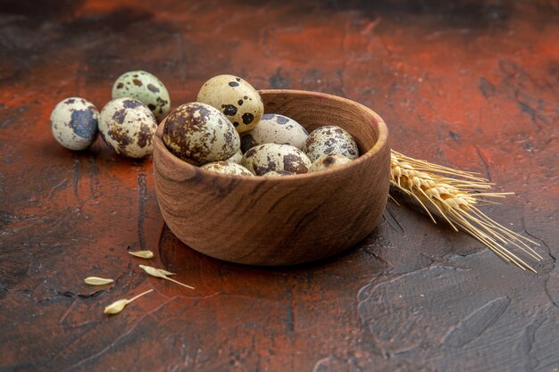 Side view of farm fresh eggs inside and outside of a wooden pot on a brown background