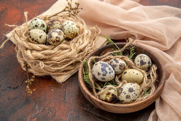 Side view of farm fresh eggs on a roll of rope on bag and on a wooden pot towel on a brown table