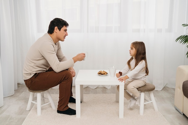 Side view of father and daughter eating together at home