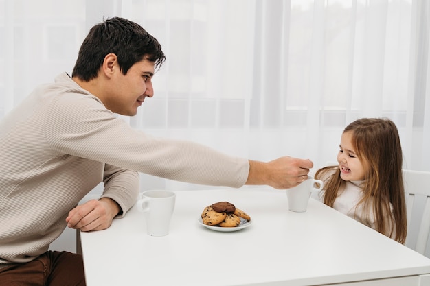 Side view of father and daughter spending time together at home