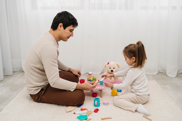 Side view of father and daughter together at home