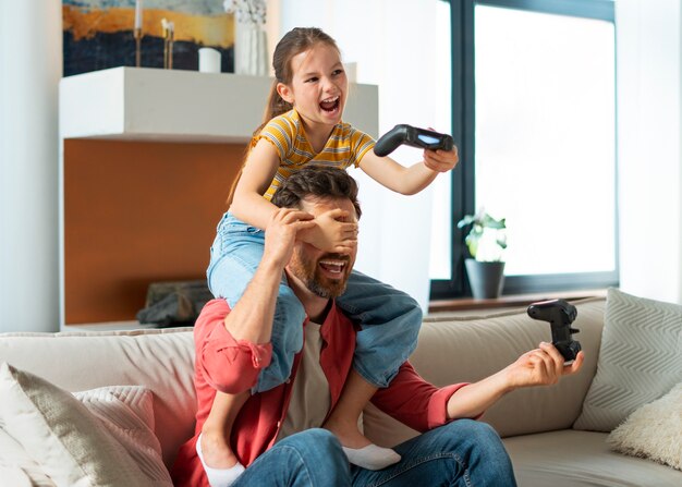 Side view father and girl playing videogame