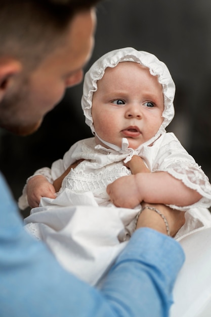 Free photo side view father holding baby