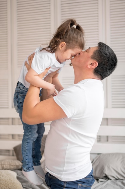 Free photo side view father kissing daughter