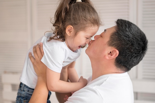 Side view father kissing girl