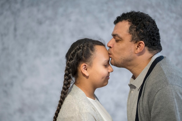 Free photo side view father kissing girl