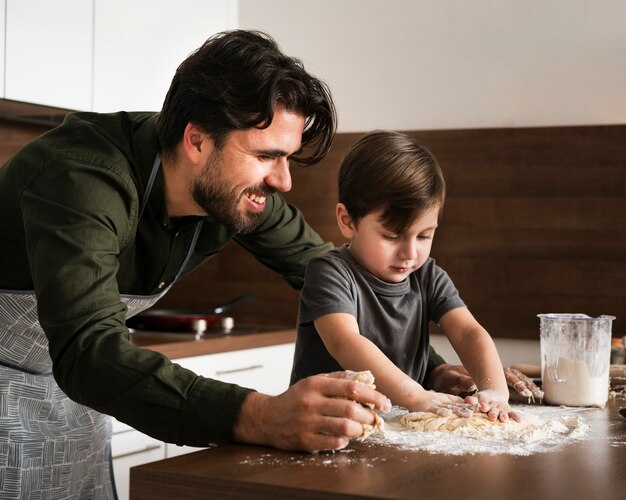 Side view father and son making dough