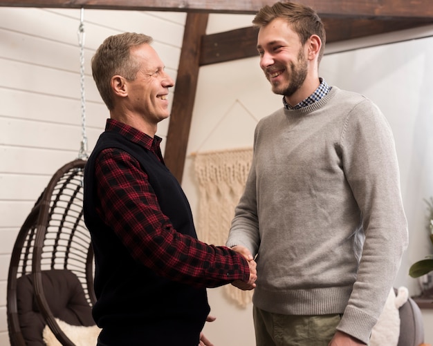 Side view of father and son shaking hands