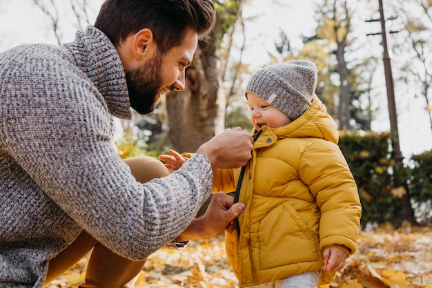 Side view of father spending time outdoors with his baby