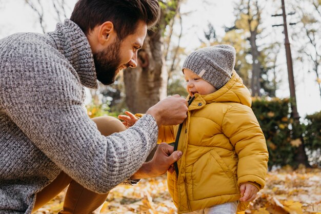 Side view of father spending time outdoors with his baby