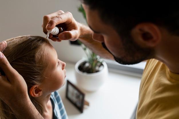 Side view father using lice treatment
