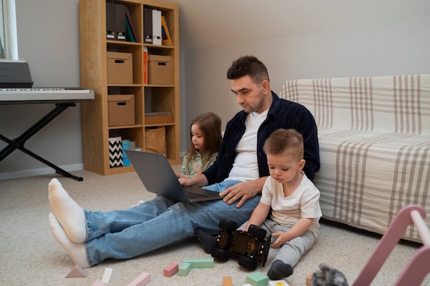 Side view father working with kids at home