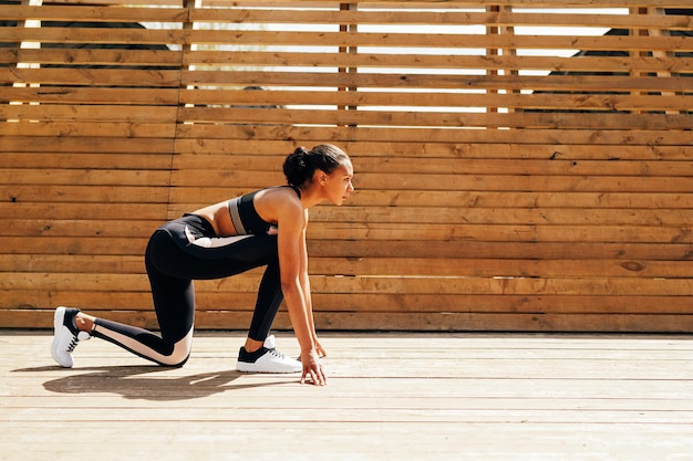 Side view of female athlete ready for running outdoors