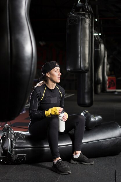 Side view of female boxer holding flask