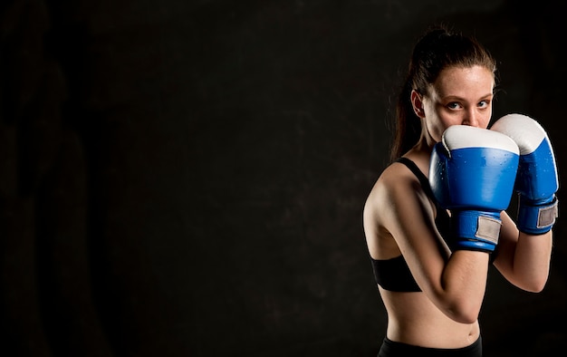 Вид сбоку женского боксера позирует с копией пространства