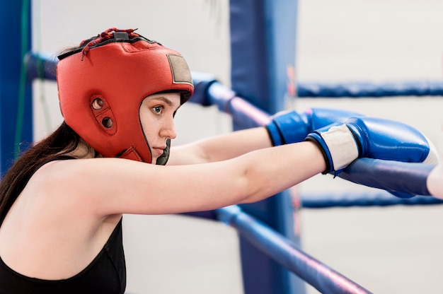 Side view of female boxer next to ring