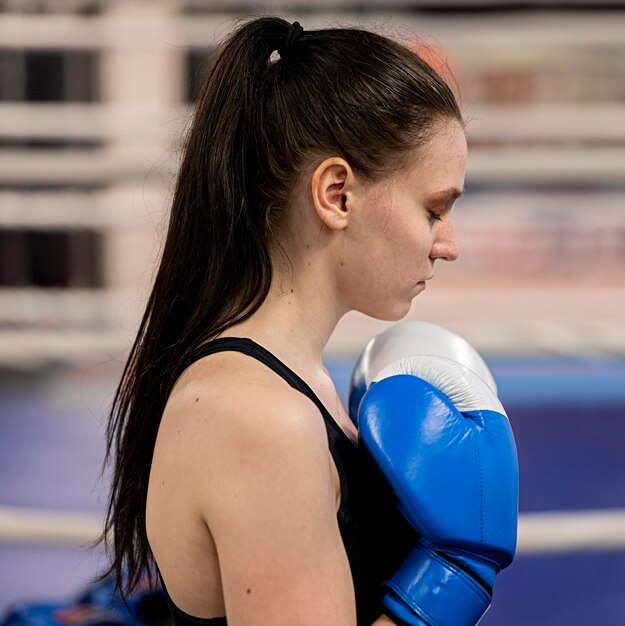 保護手袋を持つ女性のボクサーの側面図