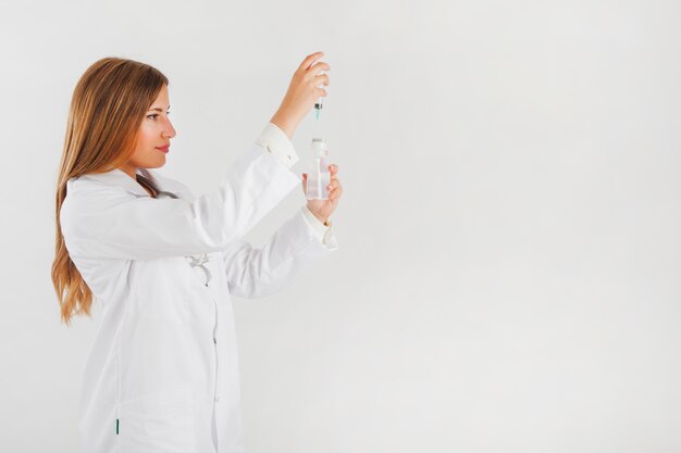 Side view of female doctor filling up needle