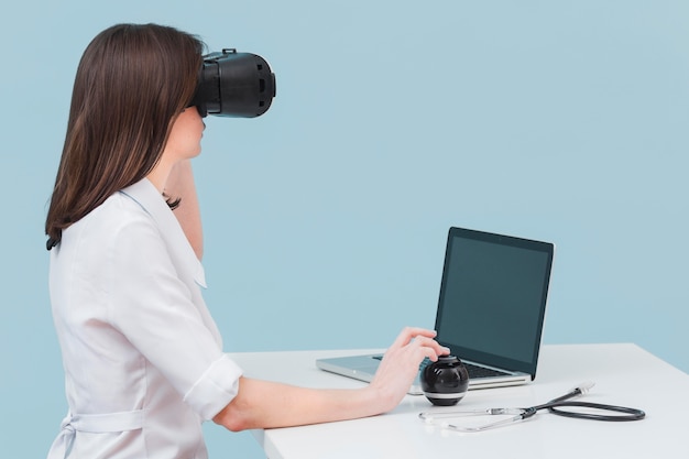 Vista laterale della dottoressa utilizzando le cuffie da realtà virtuale