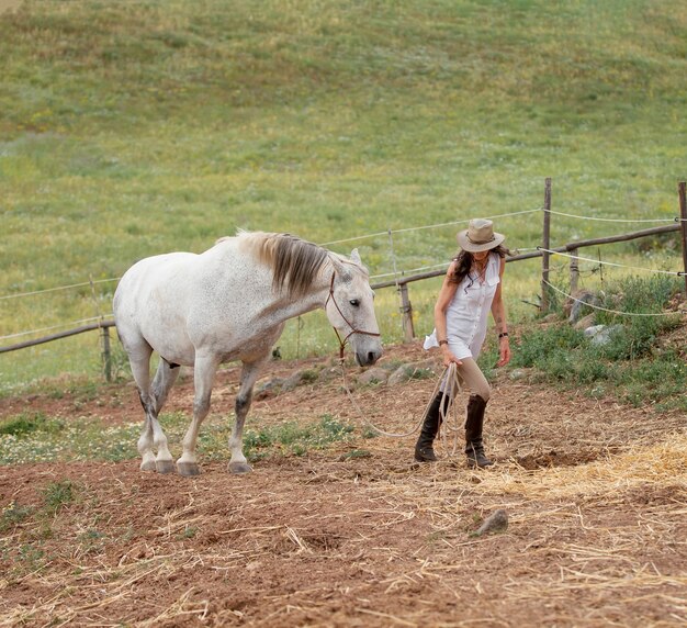 屋外で彼女の馬と女性農家の側面図