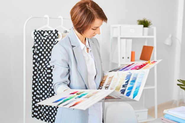 Вид сбоку женского модельера, консультирующего цветовую палитру для линии одежды