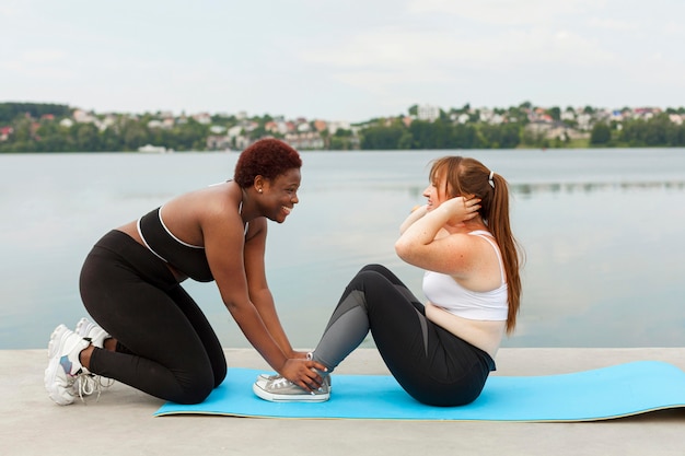 Side view of female friends exercising outdoors