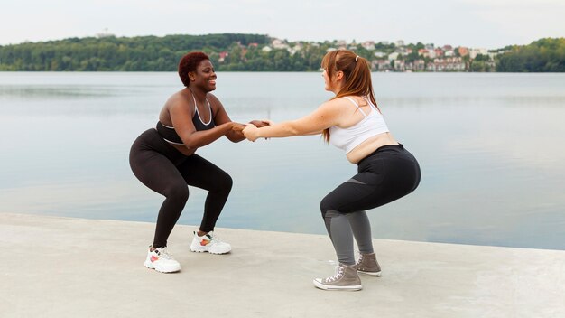 Side view of female friends exercising outdoors