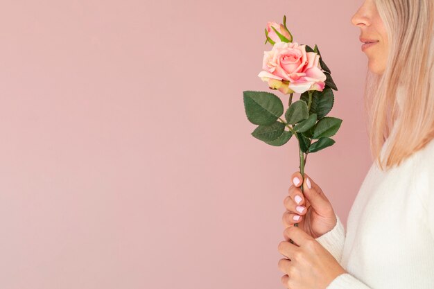 Side view of female holding rose