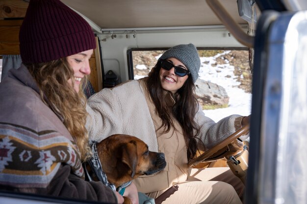 冬の旅行中に犬と一緒に女性の恋人の側面図